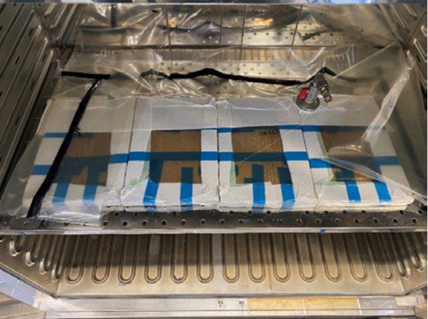 Figure 4 Lamination setup in oven with specimen packed in fleece and packed in vacuum bag.