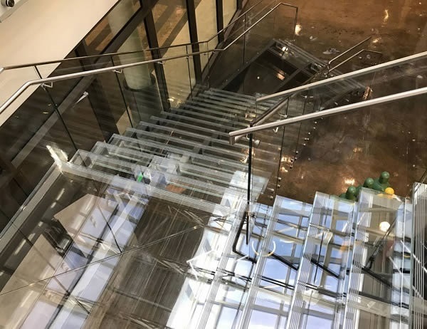 Glass treads and risers, combined with the Trex Commercial Products’ Point Series railing system, give this staircase a seamless, barely there appearance. 