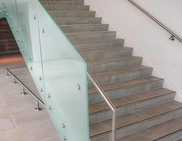 Wall-mounted handrail and cane detection rail below the lobby staircase offer added safety and security