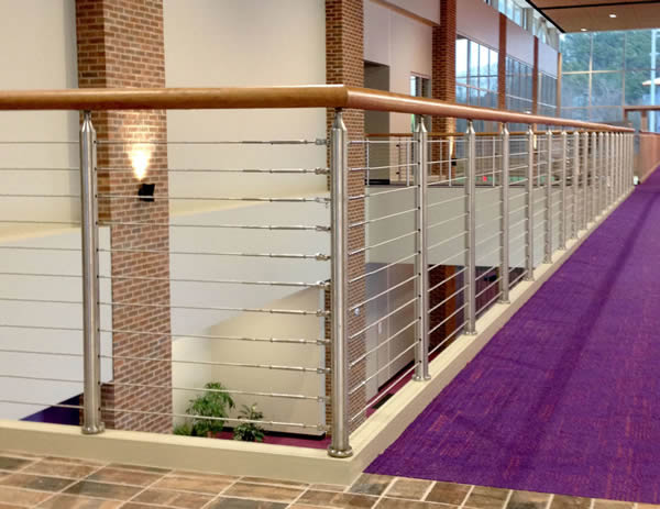 Casino cable railing with round stainless steel posts, and wood top cap is featured throughout the facility including the Paw Dining area, lounge area and next to the custom slide leading to first floor