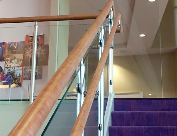 Custom wood top cap and handrails were utilized on both the cable and glass railing systems on stair and balcony overlooks throughout the facility