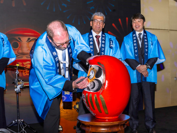 Eric Pennypacker coloring in the second eye of the Daruma doll, a traditional Japanese good-luck symbol, at the ceremony celebrating the opening of Kuraray's Middle East office, 2026.