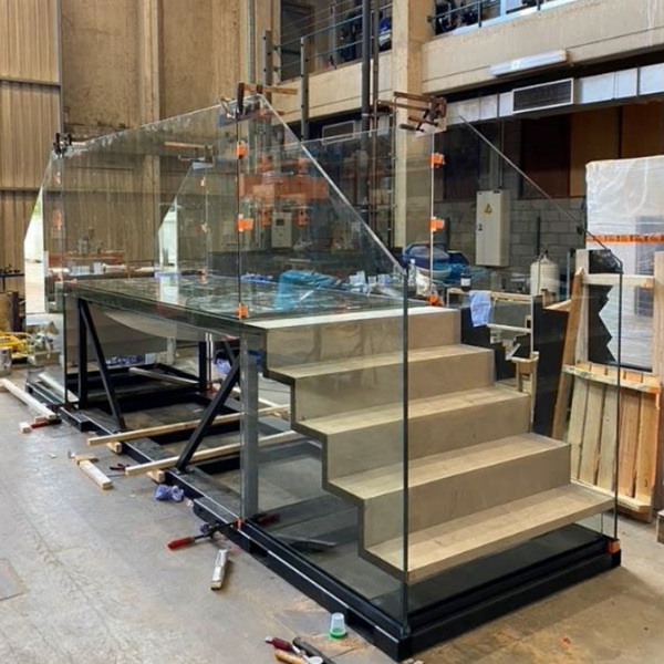 Fig. 13: The glass balustrade panels are clamped together with the side panels of the stairs, ensuring proper alignment between the separate elements.