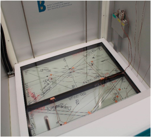 Fig. 3. Two samples of triple glazed units of 400 mm × 800 mm glued together equipped with temperature sensors on both sides in the GHP (units F and G of each brand both in one measurement). Opening of the box is possible only in the horizontal position.