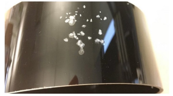 Figure 4: Ring lens of 50 µm ultrathin glass laminated on 2 mm polycarbonate after stone impact test. Delamination can be seen.