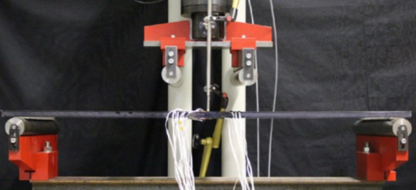 Figure 4 Experimental set-up of the four point bending test for determining the deformation and strains in the cross-section of a thin glass-polycarbonate composite panel.