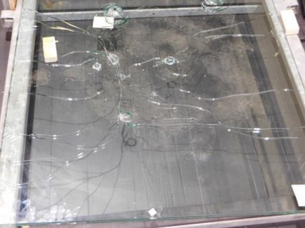 Fig. 6: Cone cracks with cracks extending from them in the heat-strengthened glass after multiple impacts