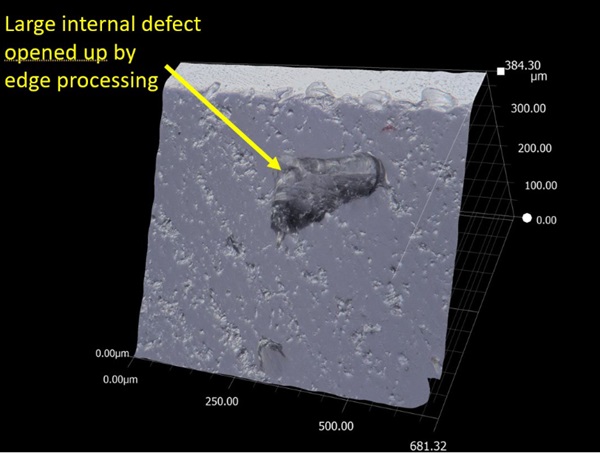 Fig. 8: Large internal 200 μm defect on arris, opened up by edge processing. Magnification 200X transmitted light.