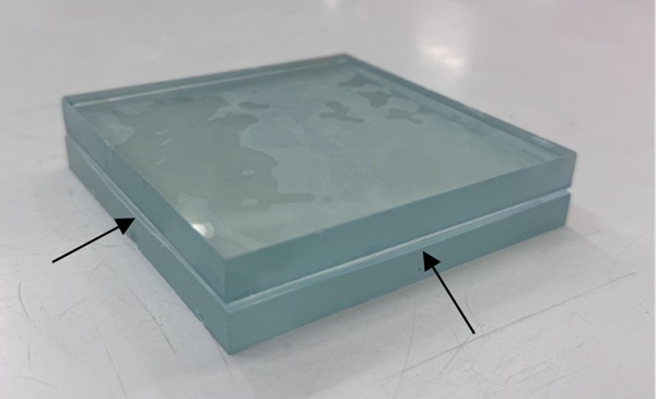 Fig. 9: The squeezing out of the TSSS film is visible upon subjection of the float glass-TSSS assembly to a compressive stress of 0.8 MPa. Despite the flatness of the float glass surfaces, non-contact zones are observed.