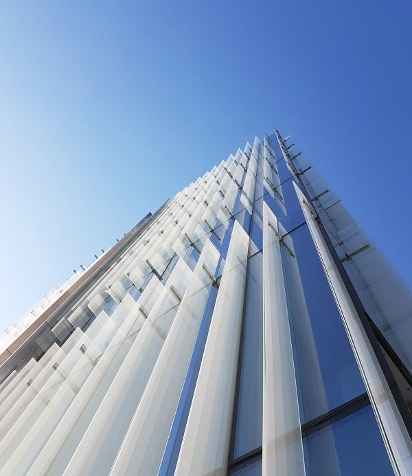 The mounting of glass fins on the glass façade establishes vertical structures which continue being the distinctive appearance of the building. | Source: Stahlbau Pichler, Bolzano