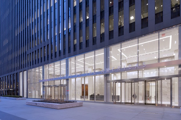 The new entrance stands in contrast with the dark skyscraper.