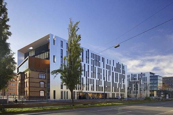 The modern new building creates an interesting contrast to the old cavalry barracks with brick façade.