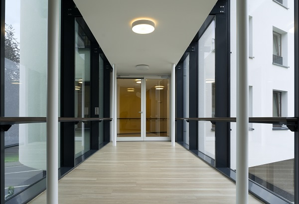 The access doors to the glass link connecting the existing building and the newbuild are safeguarded with EI30 fire protection barriers from the Schüco ADS 80 FR30 system.