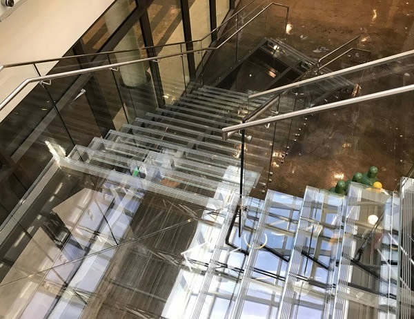 Glass treads and risers, combined with the Trex Commercial Products’ Point Series railing system, give this staircase a seamless, barely there appearance.