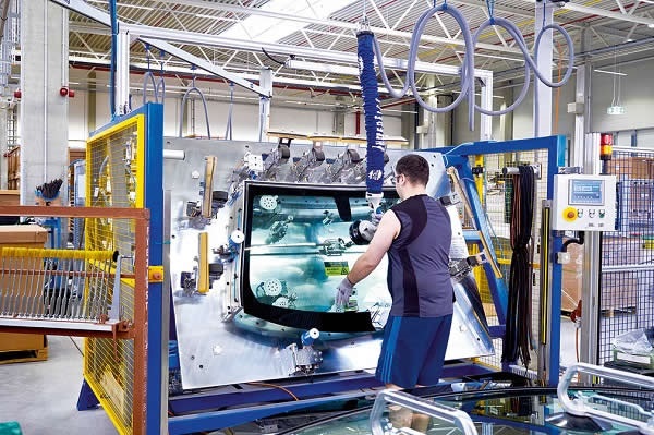 Brinas Marian positions the windshield so that the sealing gasket can be attached with precision.