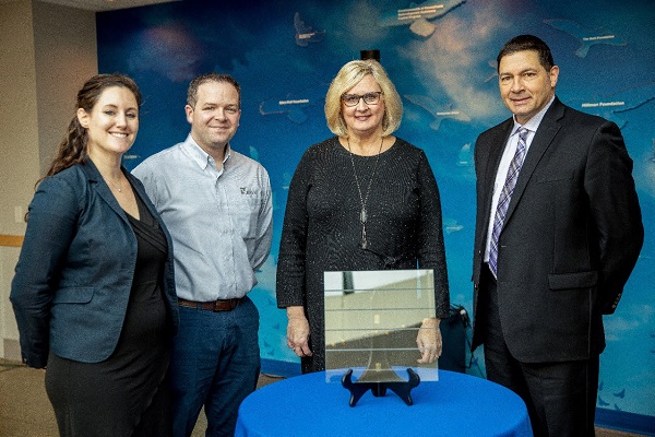 Emily Losego (far left) and Dan Sutton (left) of Vitro Architectural Glass view a sample of Solarban 72 Acuity glass featuring Pattern 213, a bird-safe acid-etched visual marker designed by Walker Glass that enables birds to see glass and avoid colliding with it. The solar control, low-e, low-iron glass will be used on The Garden Room at the National Aviary, which broke ground on December 19. Cheryl Tracy (right) executive director of the National Aviary is joined by Anthony Pitassi (far right), principal, Perfido, Weiskopf, Wagstaff + Goettel, whose firm designed the building and specified the glass.