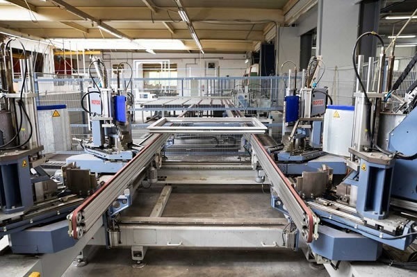 Automatic transport lines convey the frames and sashes between the processing stations, here from welding to polishing.