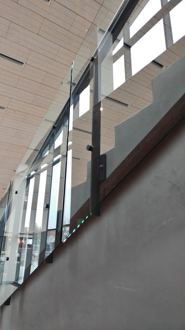 Fascia mounted posts attached to concrete using Hilti Hit-z epoxy anchors accommodate the drop side glass overhang.