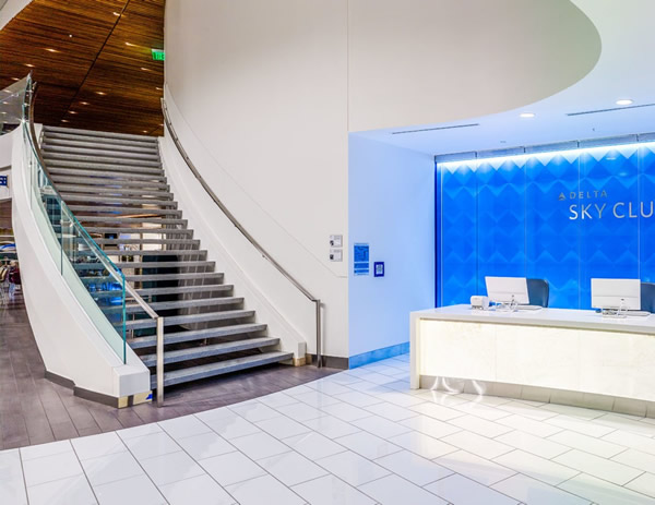 In SkyClub’s soaring two-story check-in area, the curved staircase hugs the side of the wall, allowing for a more spacious lobby, while glass railing and stainless steel handrails enhance the sleek, modern ambiance.