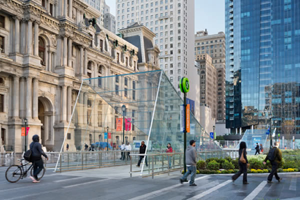 Perhaps among the largest constructions of laminated structural glass ever erected, the pavilions curve gently to the ground plane, seeming to slide under the central walkway. © James Ewing Photography