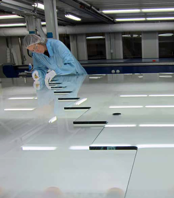 Fabricating the centre wall section of the glass staircase in the clean room at Agnora (laminator). Photo: © Agnora