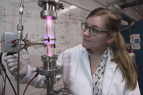 University of Minnesota researcher Samantha Ehrenberg uses a plasma reactor to create silicon nanoparticles that are the key ingredient in the solar concentrators. Credit: Patrick O'Leary, University of Minnesota