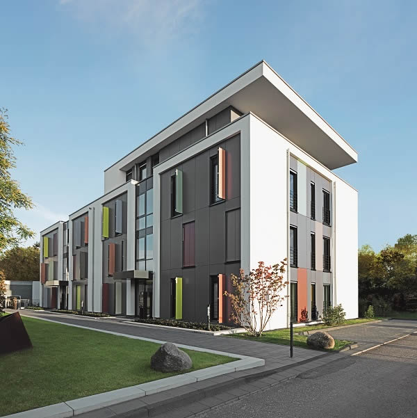 White plastered surfaces, grey façade panels and coloured screening units in front of the Schüco Corona SI 82 energy-saving windows contribute towards the creation of a vibrant, individual façade design.
