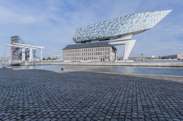 The new headquarters for the Antwerp port authorities is a result of the interaction between three spatial elements: the existing listed building, a concrete bridge and the vertical extension.