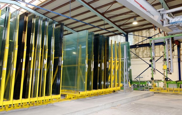 Compact storage with portal crane feeding in insulated glass production.