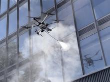 AERAS drones have the capacity to serve as an alternative to traditional commercial window and glass façade washing thanks to an onboard power washing system. (Photography: AERAS)
