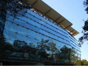 The building’s south-facing side features a bowed glass façade set out from the building as a 'rain-shield' that allows circulation edges to be naturally ventilated.