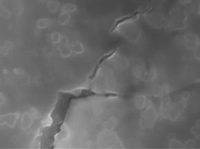 Electron microscope image of nanoparticle-toughened glass. The nanoparticles act as atomic roadblocks to deflect cracks from traveling straight and stop them propagating through the material.