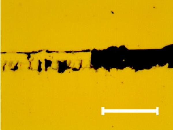 Characteristic optical image of the scratch track section where the full delamination of the chromium thin film occurs. The same fracture can be observed on the other samples. Mark size 10 μm