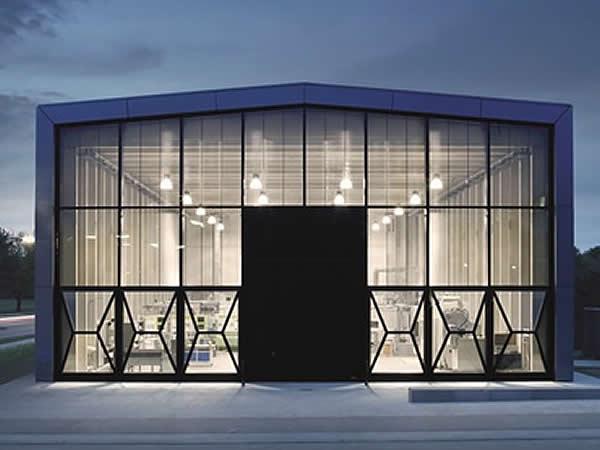 The louvre blades integrated in the space between the panes on the south façade direct solar radiation onto the ceiling of the hall. The louvre blades integrated in the space between the panes on the south façade direct solar radiation onto the ceiling of the hall.