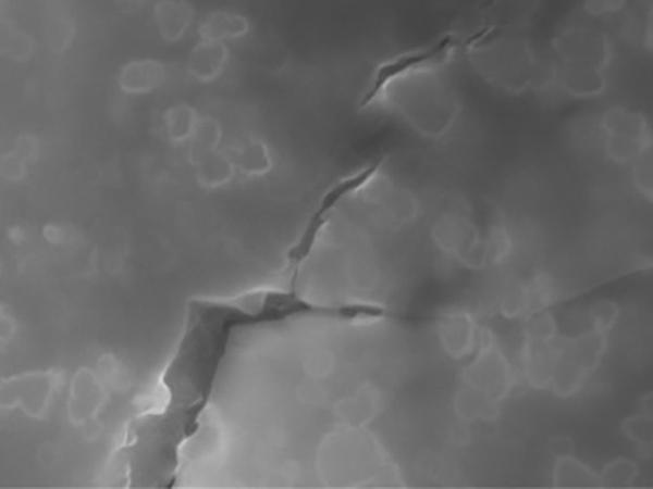 Electron microscope image of nanoparticle-toughened glass. The nanoparticles act as atomic roadblocks to deflect cracks from traveling straight and stop them propagating through the material.