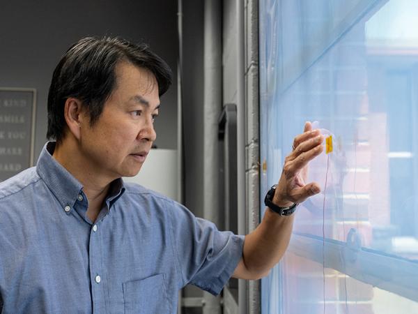 Kosol Kiatreungwattana examines temperature sensors on a window at the Denver Federal Center in Lakewood, Colorado, at a test area for emerging window technology. 